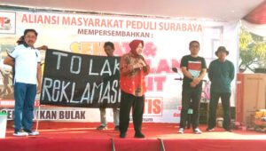 Eks Wali Kota Tri Rismaharini, Membuka Acara Jalan Sehat Dengan Membawa Bendera Tolak Reklamasi